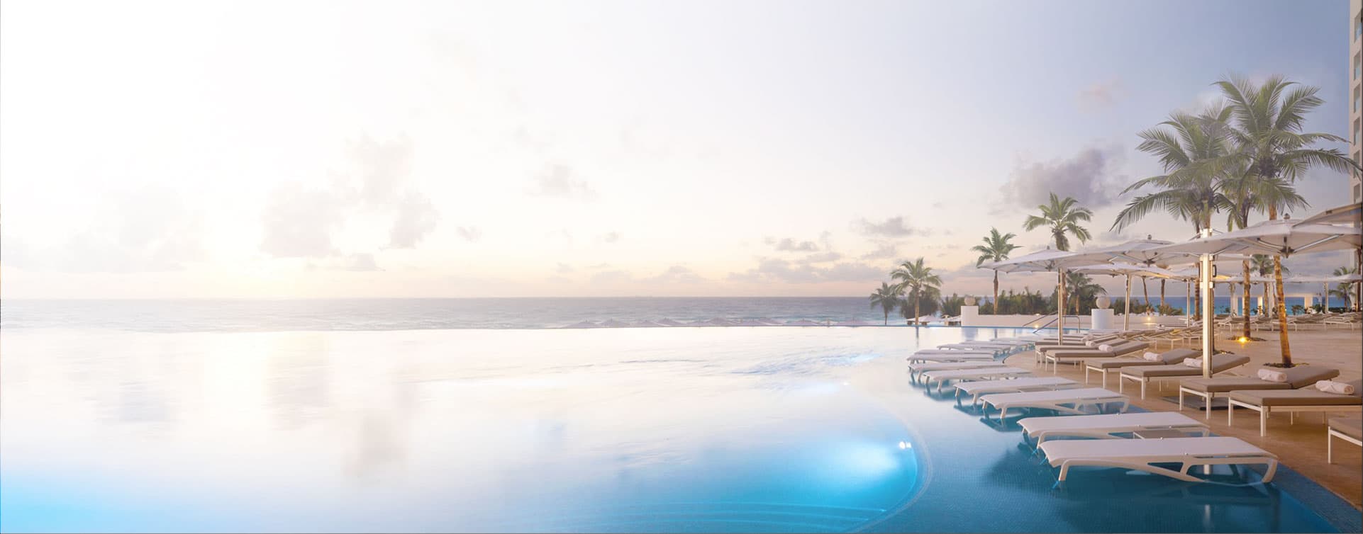 Piscine à débordement face à l'océan au coucher du soleil